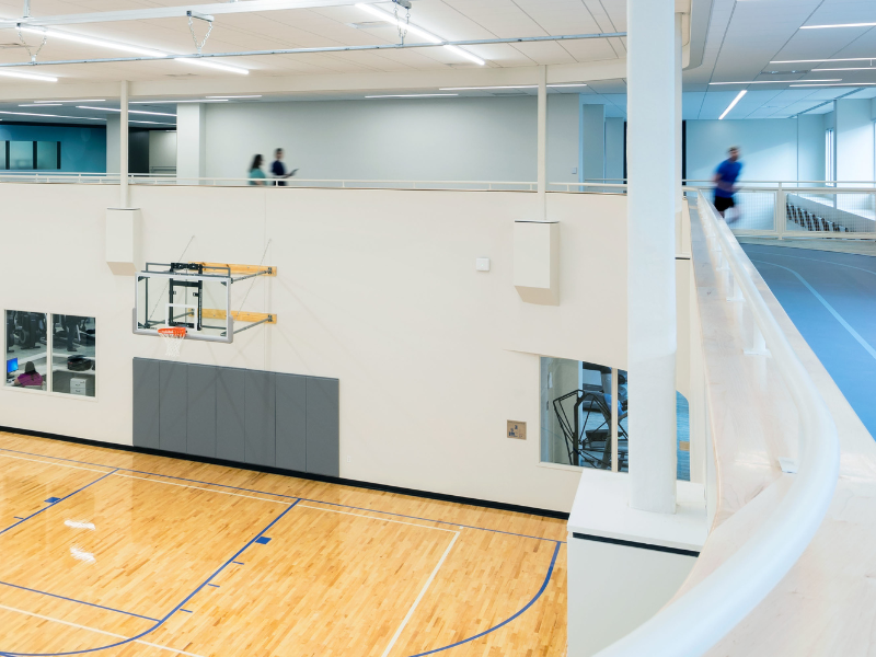 woman running on track above basketball court