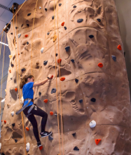 woman climbing rock wall